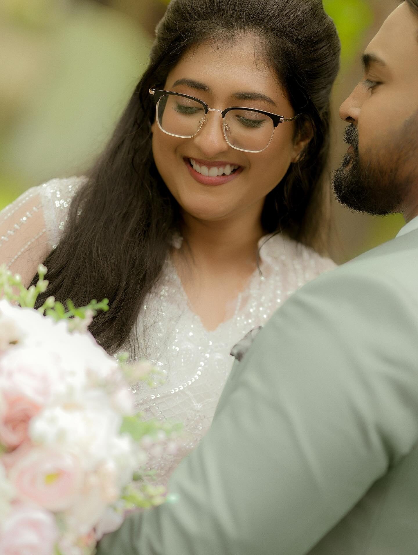 A bride and groom smiling together in a garden